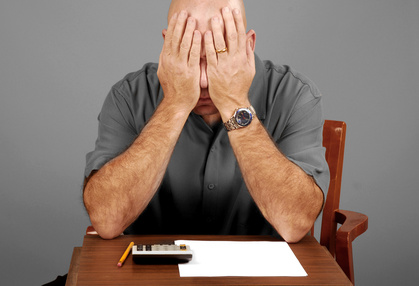 Man showing signs of stress while working budget